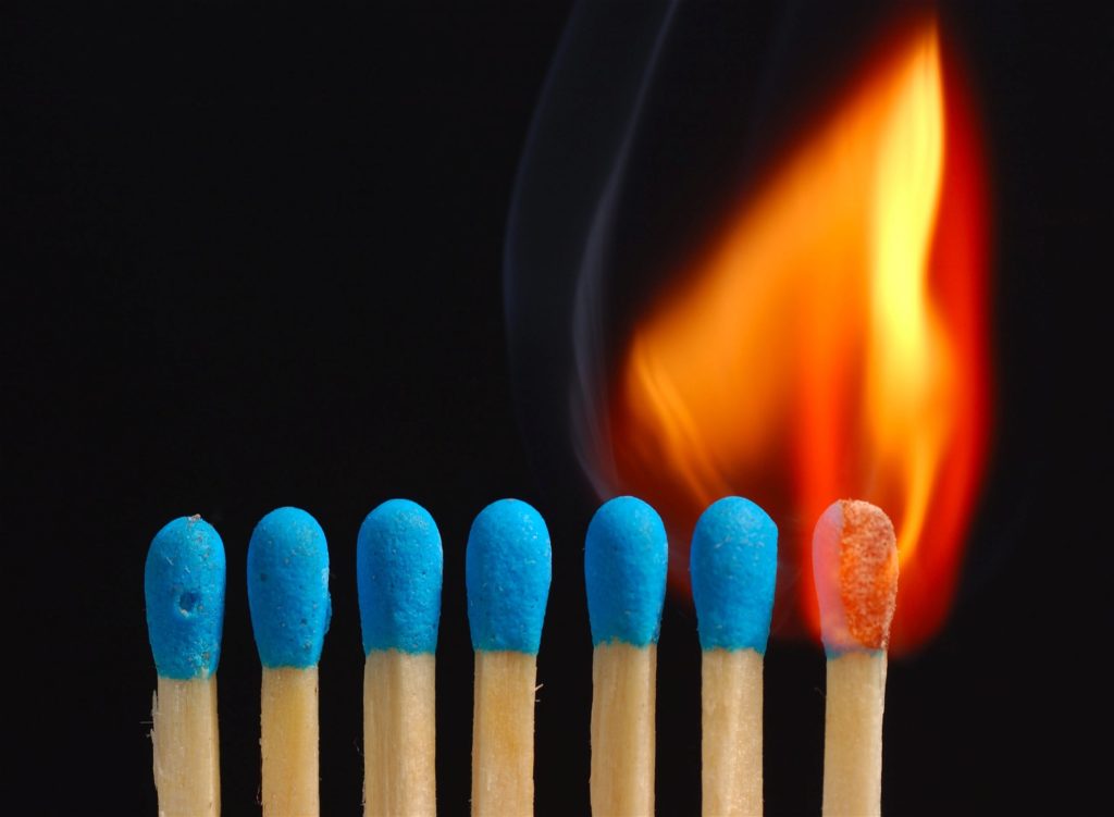 a flame spreads from one match to the unlit line of matches next to it